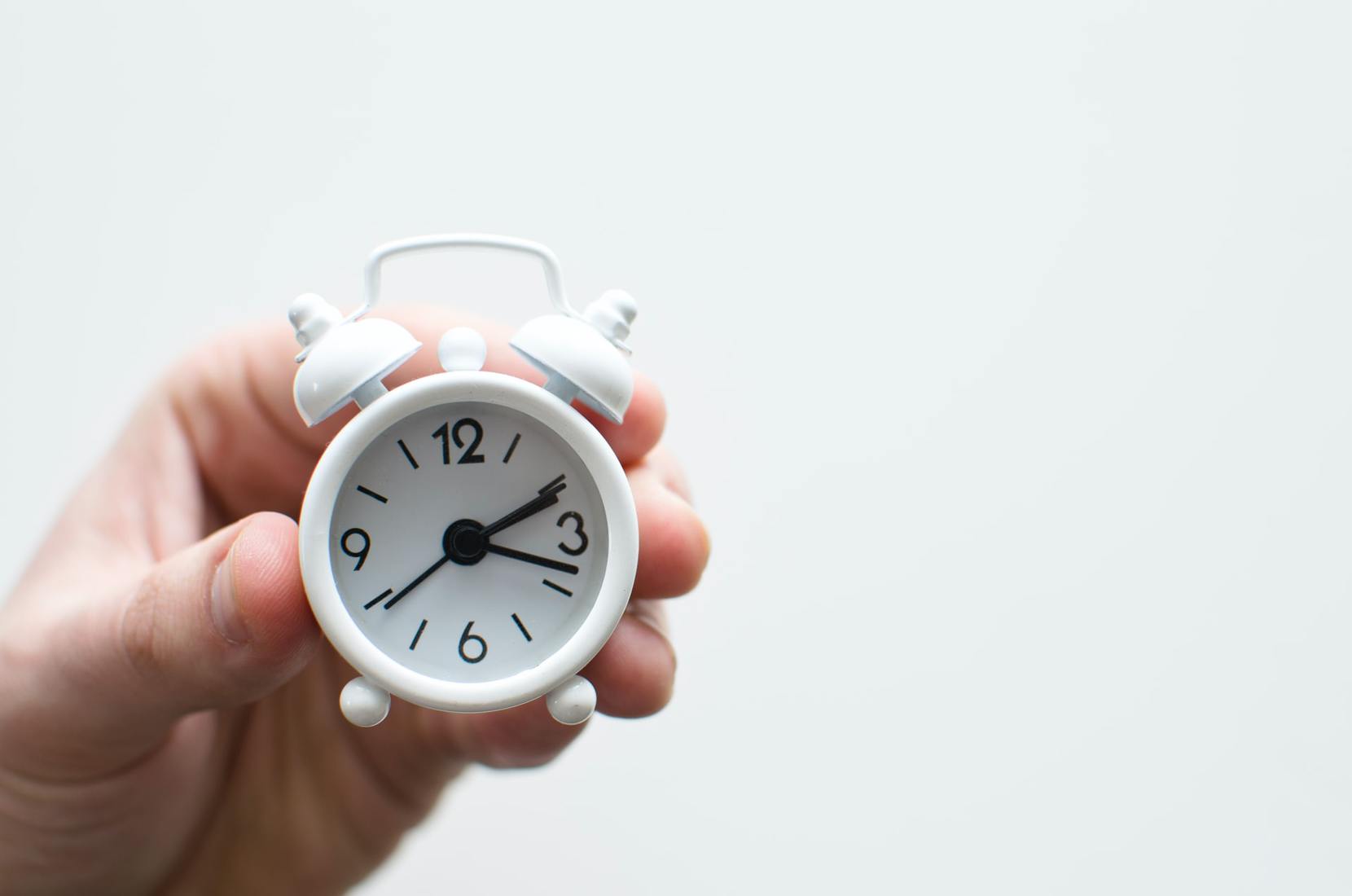 Person holding small clock