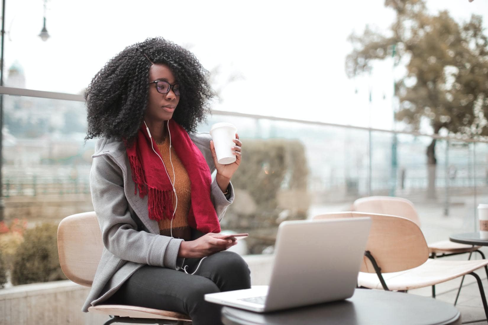 Woman drinking coffee and using laptop