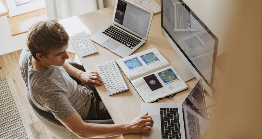 Man using 3 computers