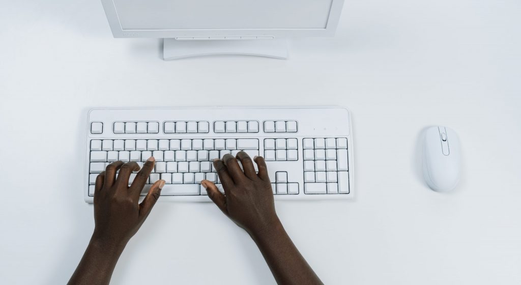 Person using white computer keyboard