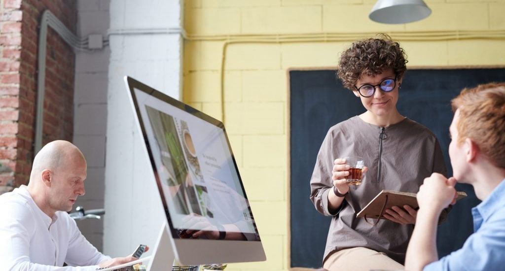 Man in blue collared top using imac indoors