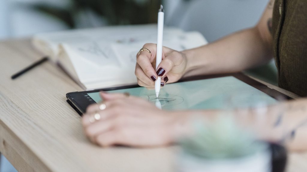 Anonymous female designer using tablet for drawing