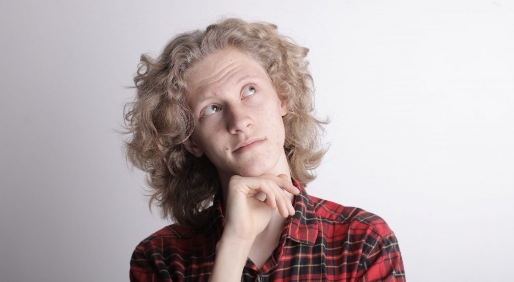 Pensive male teen on gray background