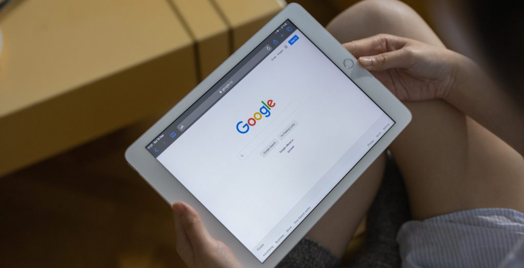 A person holding white ipad mini