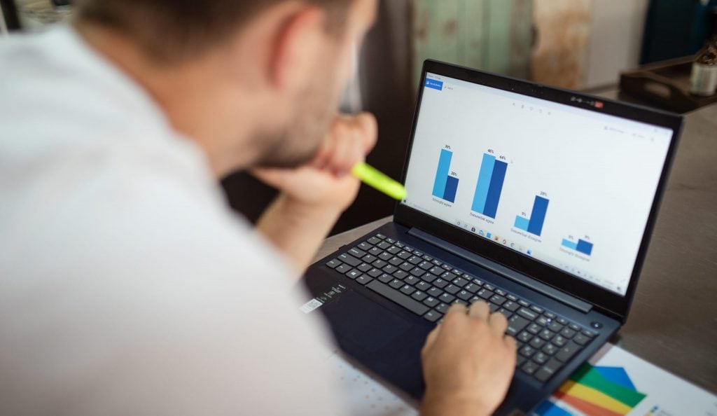 Man in white shirt using black laptop computer