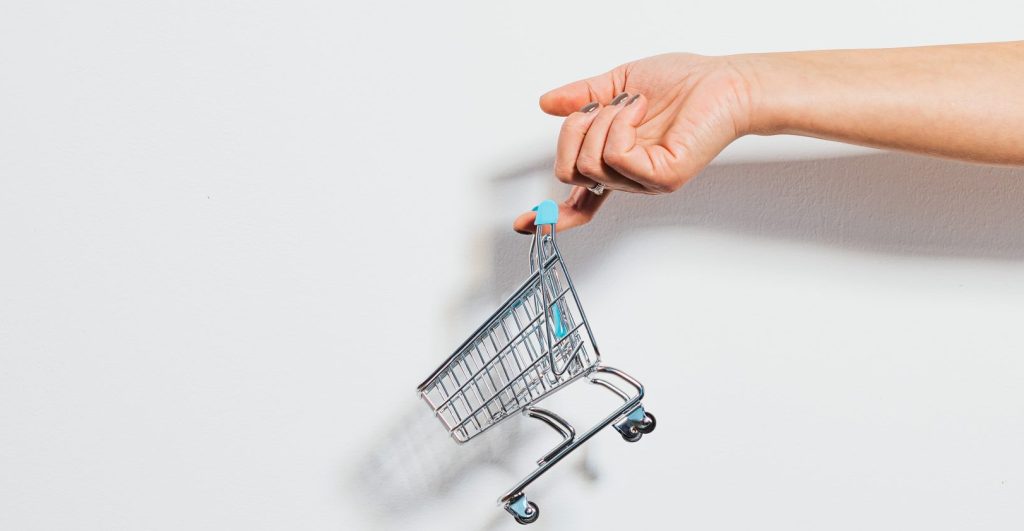 Tiny shopping cart hanging on a finger