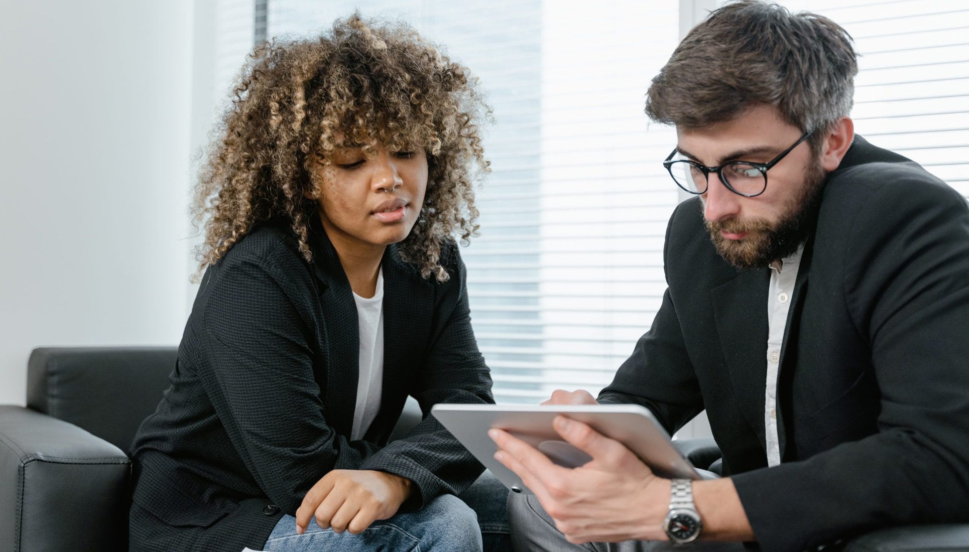 Photo of a man and a woman looking at a tablet together